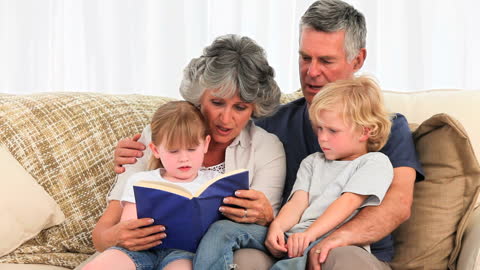 Grandparents Reading Storybook to Children on Couch