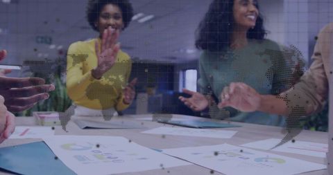 Diverse Team Collaborating Around World Map and Documents