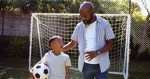 Father coaching son for passionate soccer game