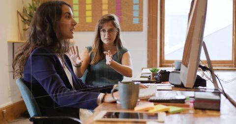Business Women Analyzing Data in Casual Workspace Office