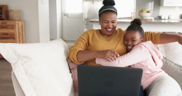 Mother and Daughter Smiling and Hugging While Using Laptop on Couch at Home - Download Free Stock Images Pikwizard.com