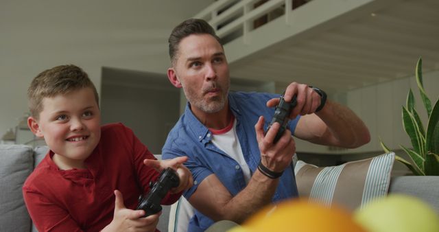 Father and Son Having Fun Playing Video Games Together in Modern Living Room - Download Free Stock Images Pikwizard.com