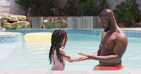 African american father and daughter bonding in pool play