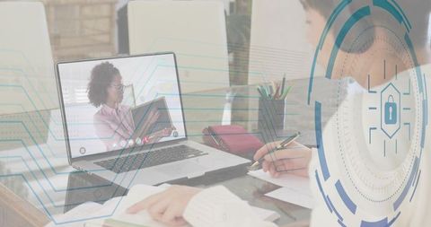 Teen taking notes during online tutoring session with cybersecurity interface overlay