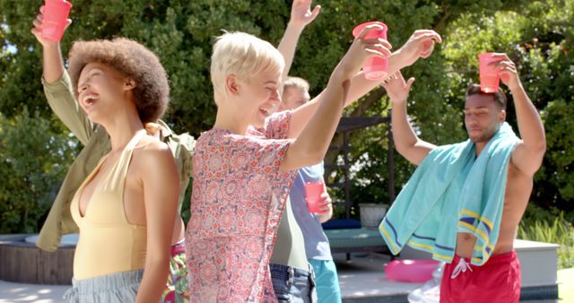 Young adults enjoying sunny pool party, holding drinks, raising cups, celebrating together. Perfect for summer social events, outdoor activities, friendship gatherings promotions.