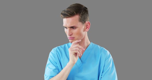 Male Nurse in Scrubs Contemplating on a Grey Background - Download Free Stock Images Pikwizard.com