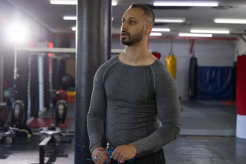 Indian man holding jump rope in gym preparing for cardio boxing training focused athlete
