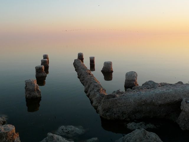 Calm Sunset Water Scene with Remnants of Wooden Piers - Download Free Stock Images Pikwizard.com