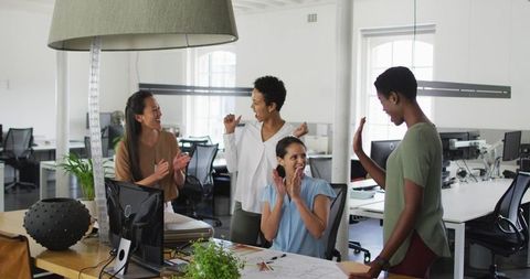 Women Celebrating Success at Modern Office Workspace