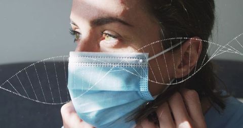 Adjusting surgical mask on contemplative woman with dna helix overlay, sunlit portrait