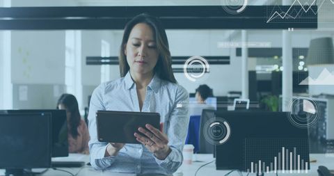 Businesswoman Using Tablet with Financial Data Graphics Overlay