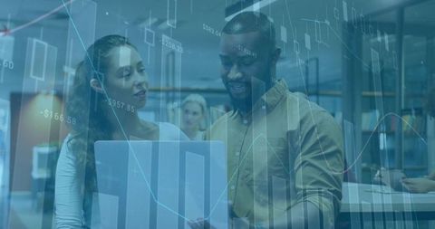 Team Collaborating with Financial Charts and Laptop in Office