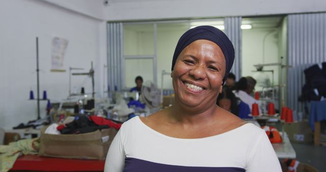 Smiling Woman Working in Clothing Factory with Sewing Machines - Download Free Stock Images Pikwizard.com