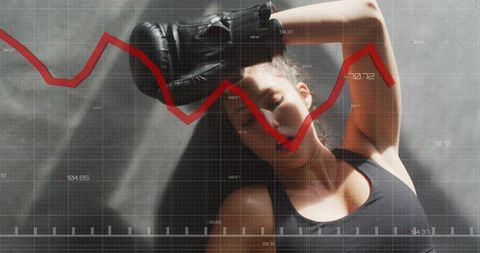 Female boxer resting on gym floor with red trend line overlay showing performance metrics
