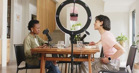 Diverse Podcasters Recording Conversational Interview at Home Studio with Ring Light