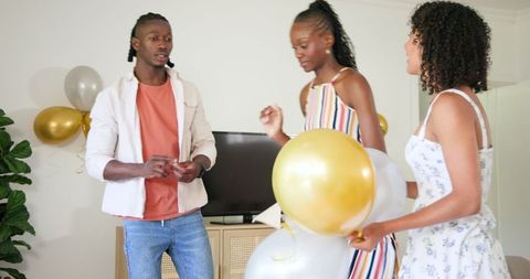 African American Friends Decorating Living Room for Party