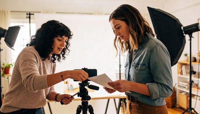 Women Collaborating on Product Shoot with Camera Tripod and Studio Lighting Setup