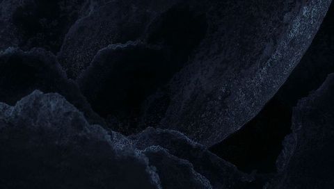 Revealing dark mineral sphere and granular rock macro closeup with cavernous texture