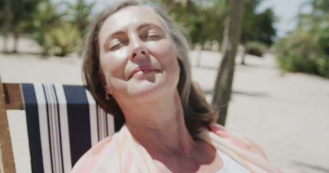 Relaxed senior woman sunbathing on beach chair - Download Free Stock Images Pikwizard.com