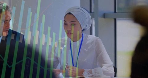Woman wearing hijab presenting financial data at conference panel with bar chart overlay