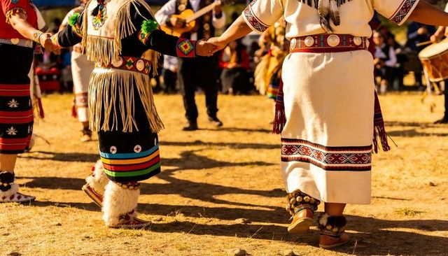 Native american powwow dancers holding hands in circle wearing traditional regalia
