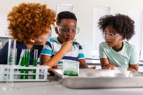 School boys conducting hands-on science experiment with test tubes and safety goggles