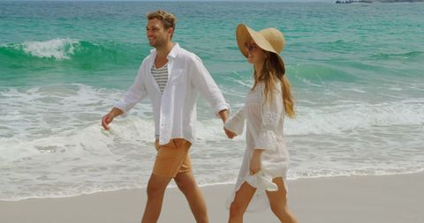 Romantic Walk on Beach: Couple Holding Hands by Ocean