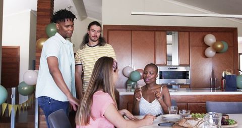 Friends enjoying social gathering around dining table