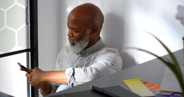 Senior African American Man Sitting at Home Using Smartphone - Download Free Stock Images Pikwizard.com