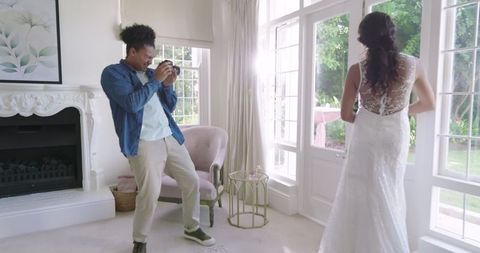 Photographer capturing bride in sunny elegant room