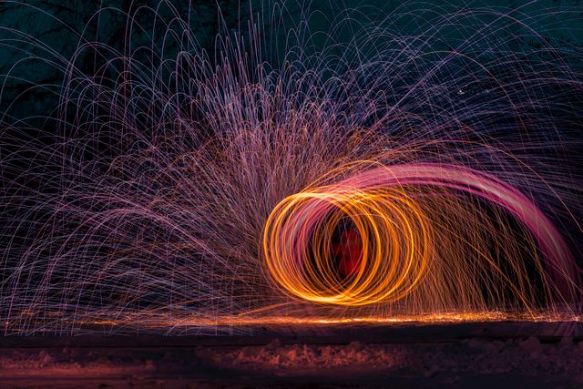 Capturing brilliant streaks of light through the process of spinning burning steel wool. Perfect for artistic projects, creative backgrounds, technology or energy concepts, and could be used in publications about photography techniques.