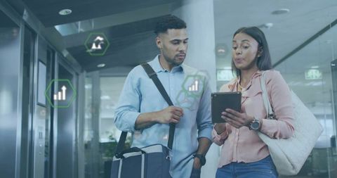 Colleagues Viewing Digital Data on Tablet in Modern Office Corridor