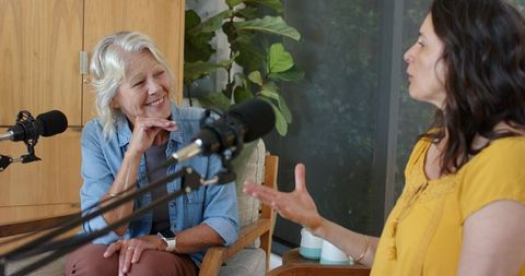 Senior guest and host recording cozy podcast interview with boom mic conversation