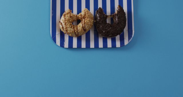 Two Donuts with Different Toppings on Striped Paper Plate - Download Free Stock Images Pikwizard.com