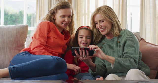 Happy Multi-Generational Family Bonding with Smartphone on Sofa - Download Free Stock Images Pikwizard.com