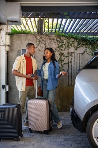 Couple preparing for an urban getaway beside suv
