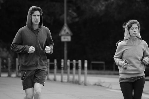 Two individuals jogging outdoors in casual sportswear