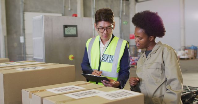 Warehouse workers in safety vests discussing inventories while examining boxes with barcodes. Useful for illustrating inventory management, logistics, teamwork, efficiency in industrial settings, and warehouse operations. Can be used for blog posts, articles on warehouse organization, business presentations, and educational materials on supply chain management.