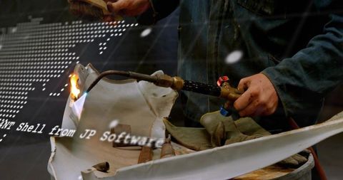 Technician heating fiberglass panel with oxy-acetylene torch for repair and fabrication