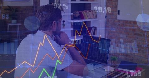 Middle-Aged Man Analyzing Financial Charts on Laptop in Home Office