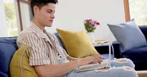 Young Man Concentrating on Laptop in Comfortable Living Room - Download Free Stock Images Pikwizard.com