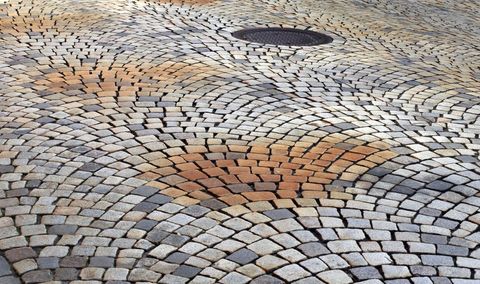 Textured cobblestone pavement with manhole cover