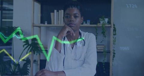 Physician analyzing medical data with green analytics overlay in modern clinic workspace