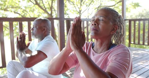 Senior African American Couple Practicing Meditation on Porch