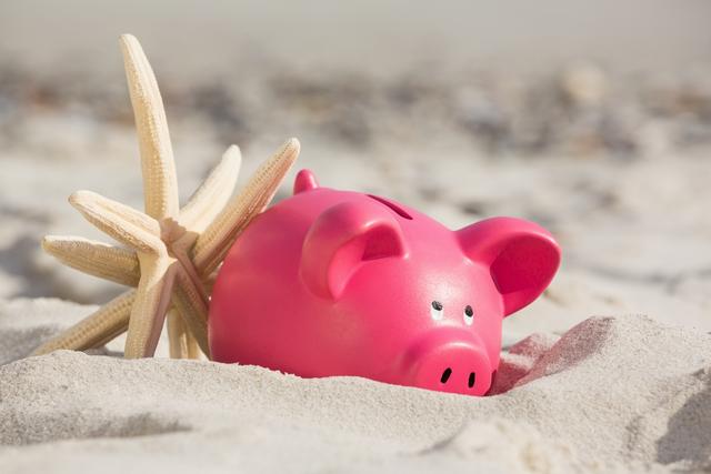 Piggy bank and starfish on sandy beach, ideal for concepts related to vacation savings, financial planning for holidays, and summer travel. Perfect for travel agencies, financial institutions, and summer promotions.
