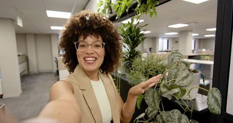African American Woman in Modern Open Plan Office with Greenery