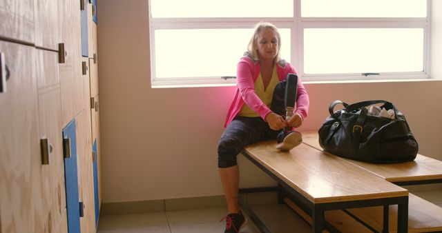 Determined Woman Adjusting Prosthetic Leg in Locker Room - Download Free Stock Images Pikwizard.com