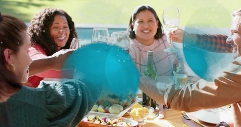 Group Celebrating Poolside Brunch Toasting with Wine on Sunny Backyard Alfresco Table