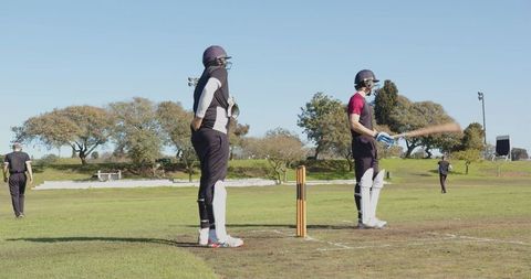 Cricket Players Training On Sunny Day in Protective Gear