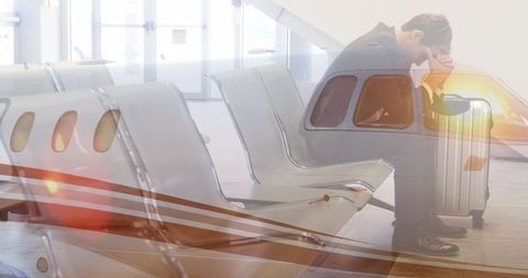 Businessman Pondering in Airport Terminal with Suitcase - Download Free Stock Images Pikwizard.com
